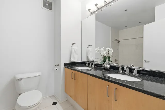 a bathroom with a granite countertop sink a toilet and a mirror