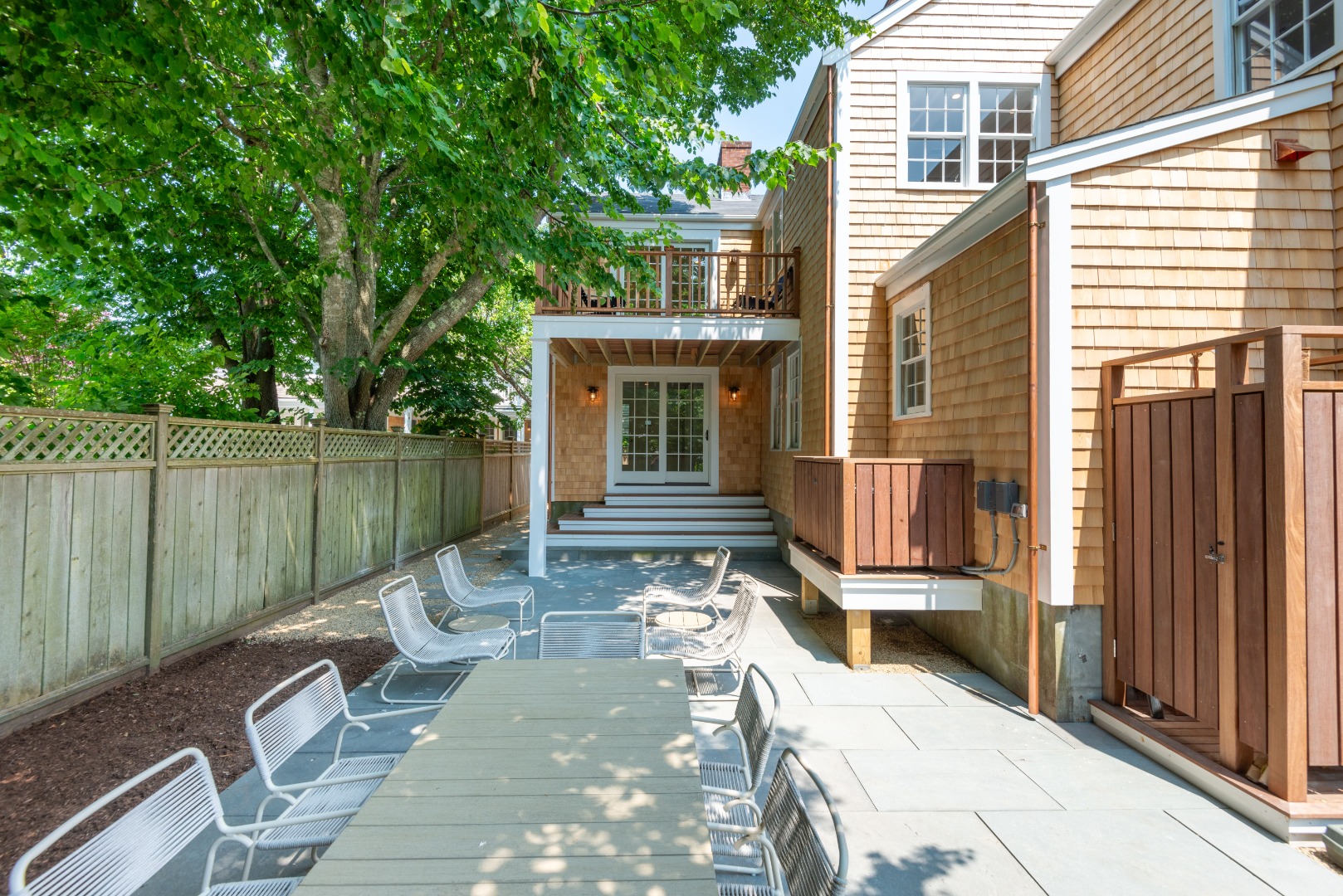 12 Willard Street Nantucket, MA 02554 - Photo 33 of 36 a view of a patio with table and chairs and wooden fence