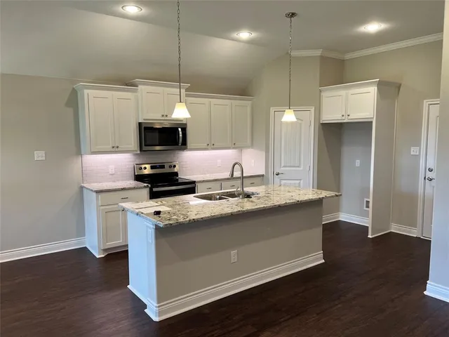 a kitchen with stainless steel appliances granite countertop a stove a sink and a refrigerator
