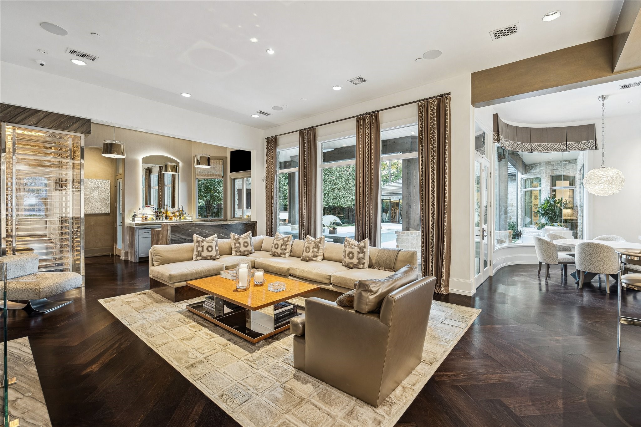 220 Merrie Way Lane Houston, TX 77024 - Photo 9 of 50 Seamless flow connects the family room to the wet bar and state-of-the-art wine room, complemented by recessed lighting and integrated in-ceiling speakers.