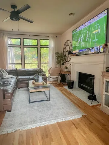 a living room with furniture a fireplace and a large window