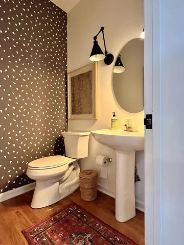 a bathroom with a toilet sink and mirror