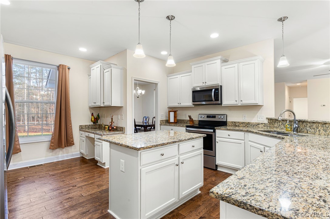1602 Blakely Road Crozier, VA 23039 - Photo 14 of 44 a kitchen with a stove a sink a microwave a center island and wooden floor
