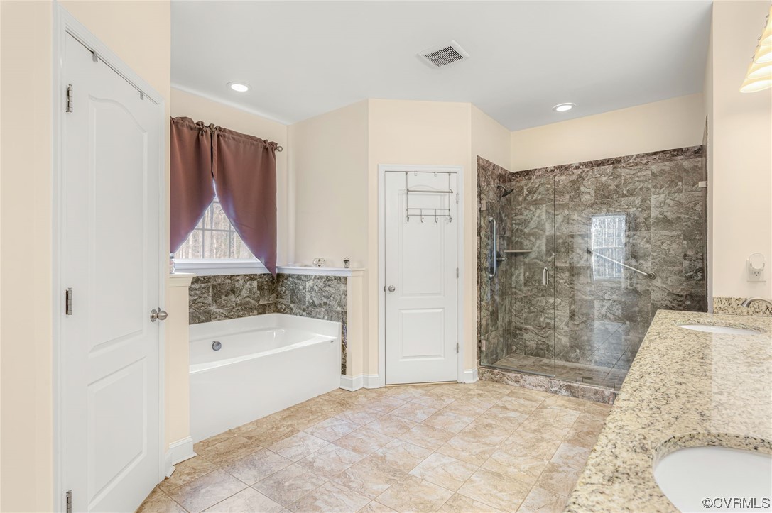 1602 Blakely Road Crozier, VA 23039 - Photo 20 of 44 a bathroom with a granite countertop sink a mirror a bathtub and shower