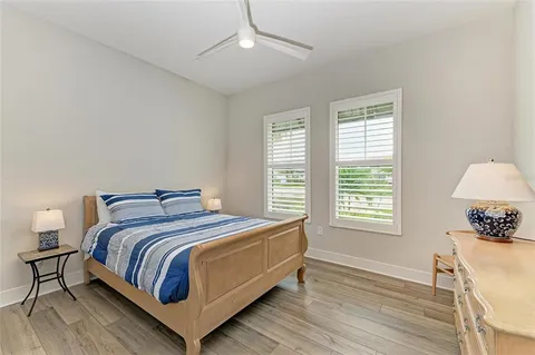 a bedroom with a bed a large window and a flat screen tv