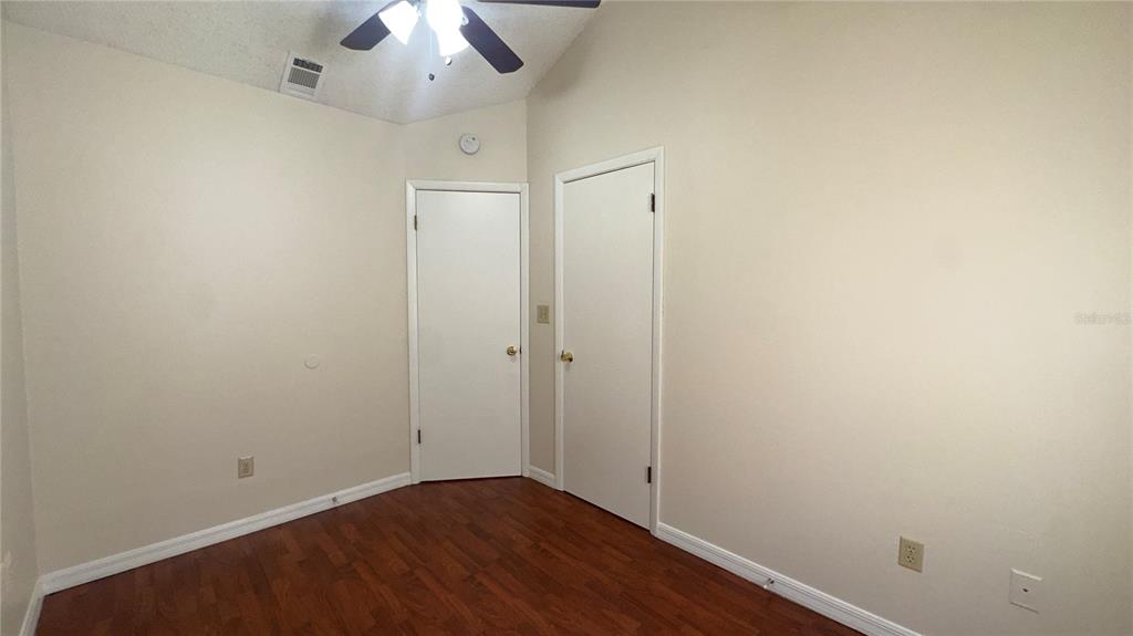 616 Massachusetts Avenue, Unit A St. Cloud, FL 34769 - Photo 11 of 15 an empty room with a ceiling fan and wooden floor