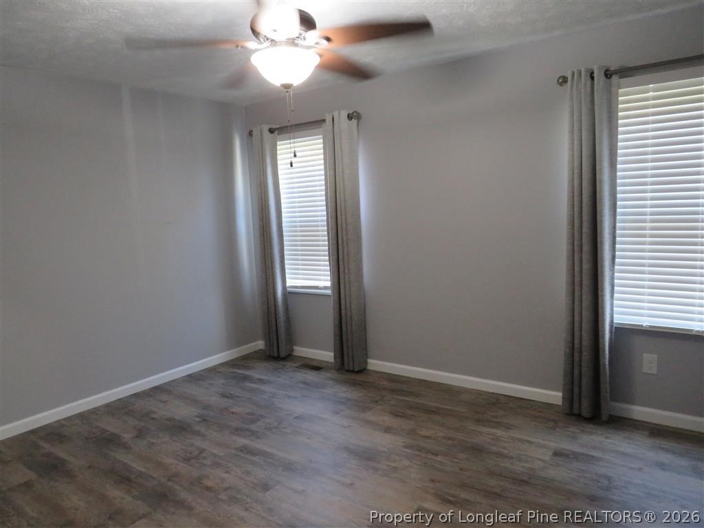 760 Ashbrook Road Fayetteville, NC 28314 - Photo 7 of 13 an empty room with windows and fan