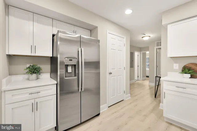 a kitchen with a refrigerator sink and cabinets