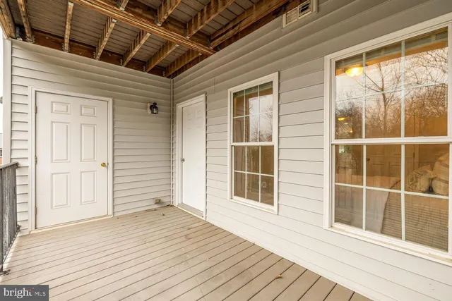 a view of empty room with wooden floor and windows