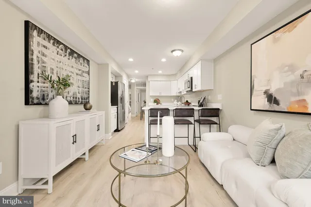 a living room with furniture and kitchen view