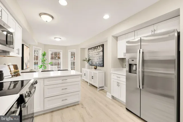 a kitchen with white cabinets and refrigerator
