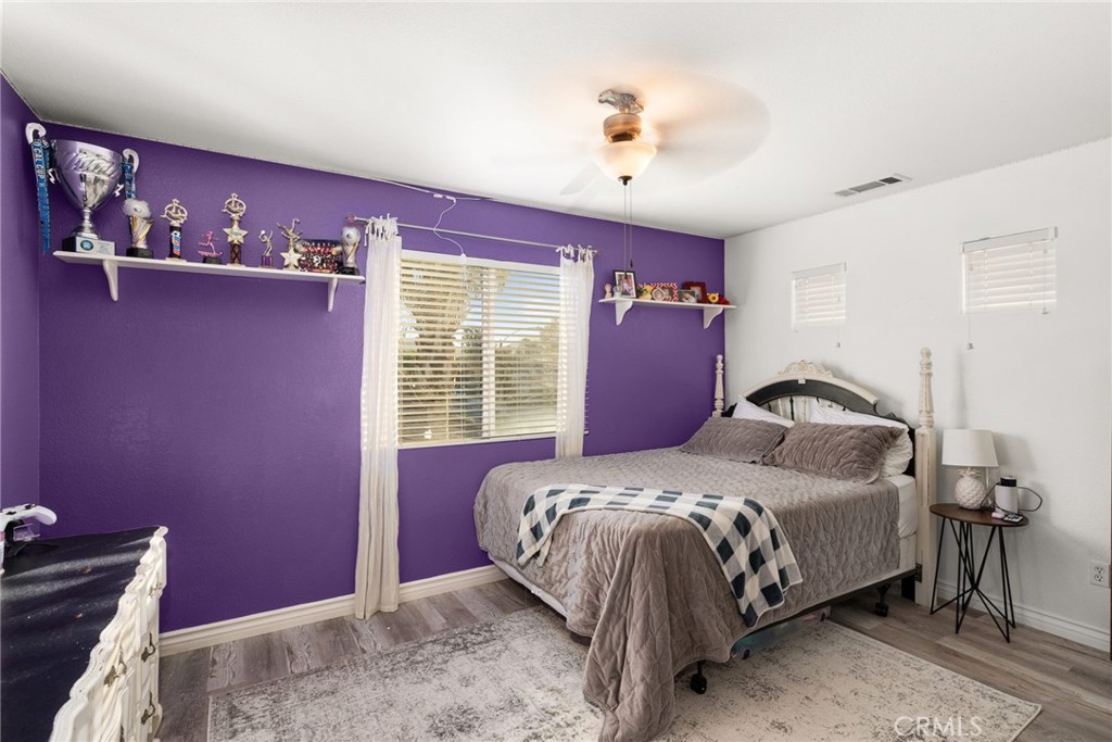 29602 Cool Meadow Drive Menifee, CA 92584 - Photo 19 of 31 a bedroom with a bed and a chandelier