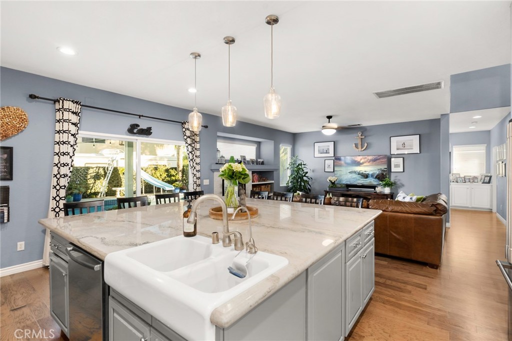 29602 Cool Meadow Drive Menifee, CA 92584 - Photo 9 of 31 a kitchen with stainless steel appliances granite countertop a sink a stove and a wooden floors