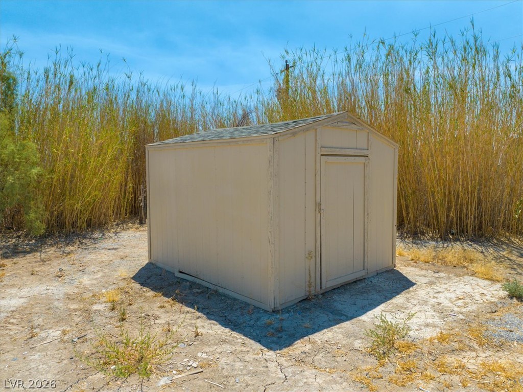4081 Retread Road Pahrump, NV 89048 - Photo 62 of 98 A quaint storage shed offers functional utility amidst natural surroundings.
