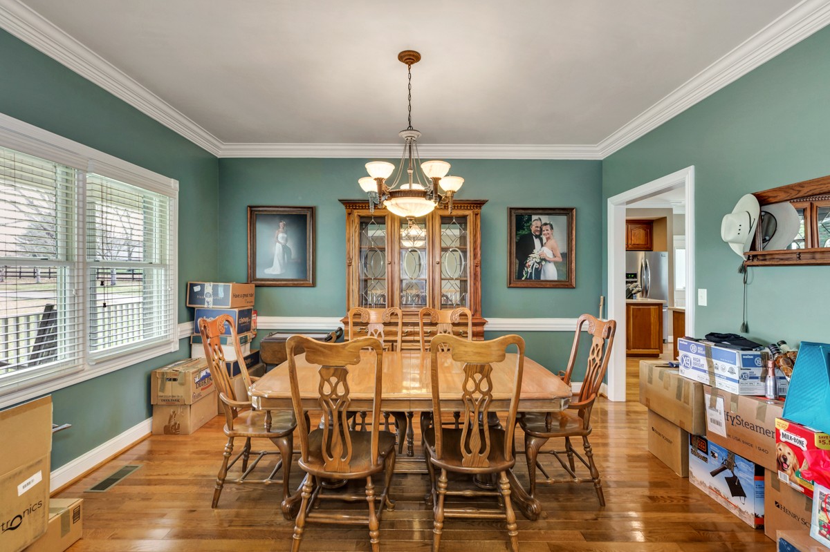 18789 Wells Road Athens, AL 35613 - Photo 13 of 40 a dining room with furniture a chandelier and wooden floor