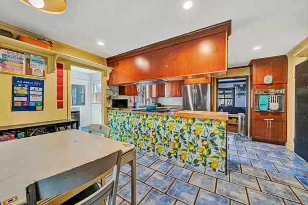 a kitchen with stainless steel appliances granite countertop a refrigerator a stove and a sink