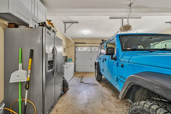 a room with lots of books and white cabinets