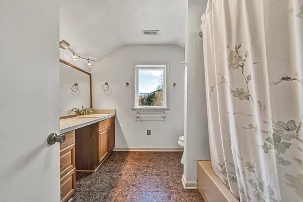 a bathroom with a granite countertop sink mirror and window