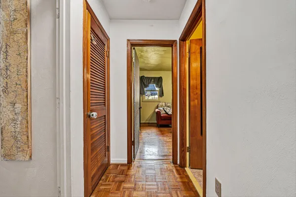 a view of a hallway with a livingroom and a bathroom