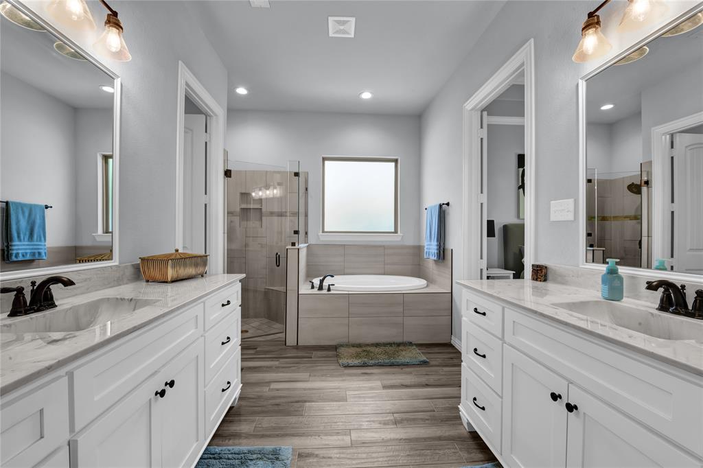 305 Familia Court Azle, TX 76020 - Photo 19 of 40 a bathroom with a granite countertop double vanity sink a mirror and a bathtub