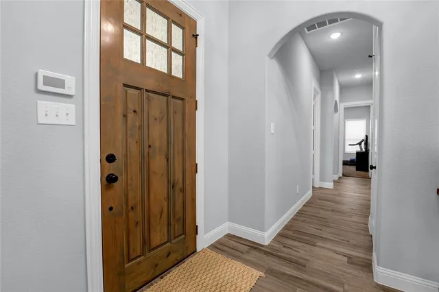 a view of a hallway with wooden floor and stairs