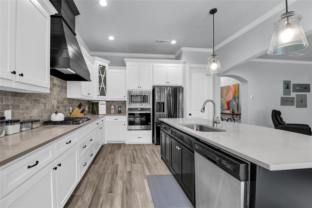 305 Familia Court Azle, TX 76020 - Photo 6 of 40 a open kitchen with stainless steel appliances granite countertop a sink a stove and a wooden floors
