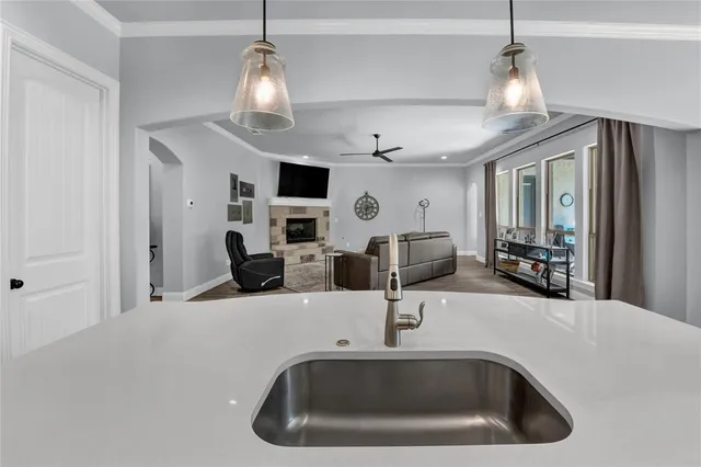 a kitchen with stainless steel appliances kitchen island a large island in the center a sink a window and chairs