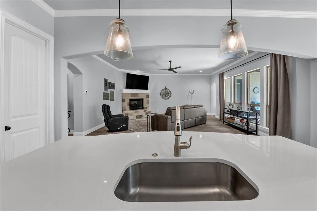 305 Familia Court Azle, TX 76020 - Photo 7 of 40 a kitchen with a sink and a chandelier
