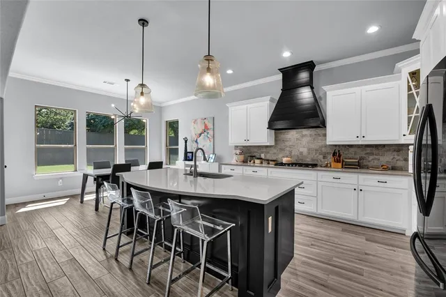 a kitchen with stainless steel appliances white cabinets and a stove top oven