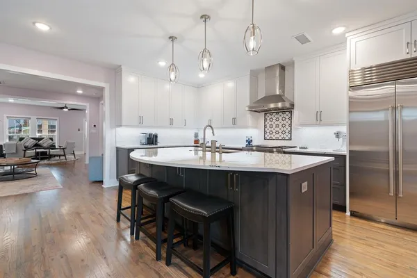 a kitchen with a sink appliances and wooden floor
