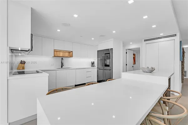 a kitchen with refrigerator and white cabinets