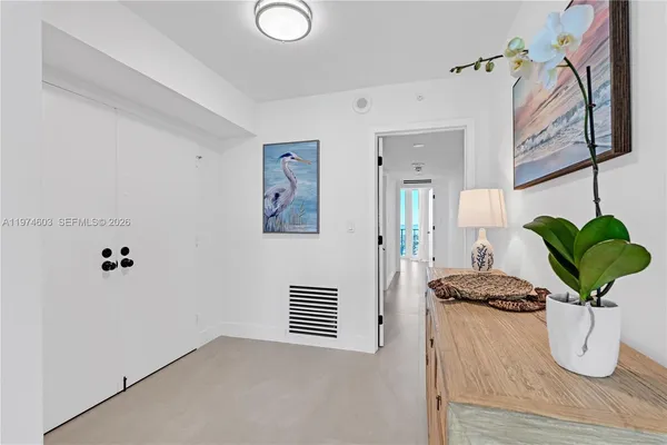 a white vase with white and yellow flowers