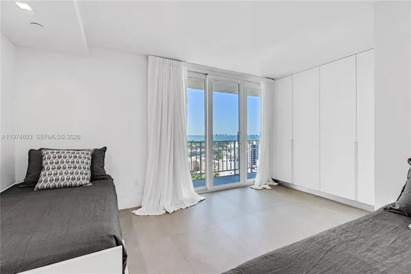 a bedroom with a large bed and a large window