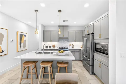a kitchen with stainless steel appliances granite countertop a sink refrigerator and cabinets