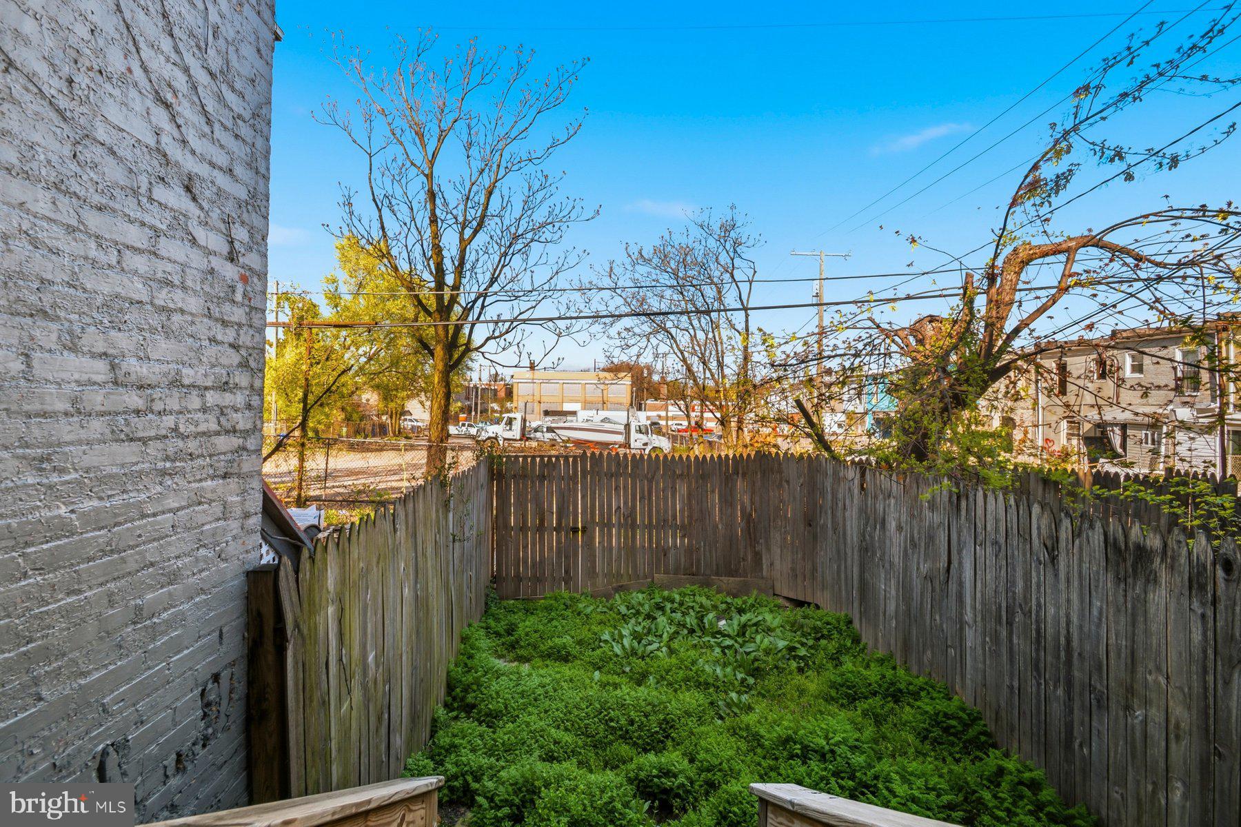 322 South Pulaski Street Baltimore, MD 21223 - Photo 13 of 28 a street view with iron fence and a tree