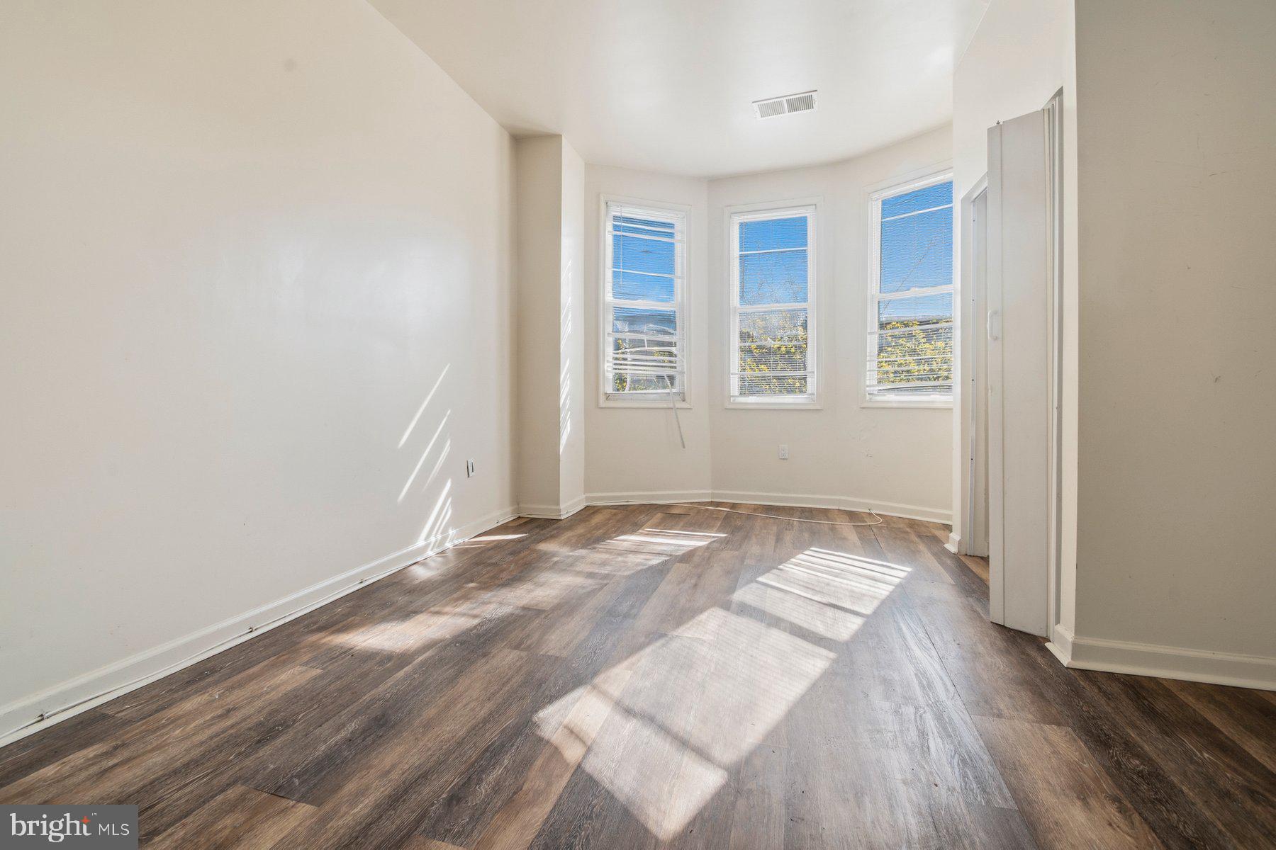 322 South Pulaski Street Baltimore, MD 21223 - Photo 21 of 28 an empty room with wooden floor and windows