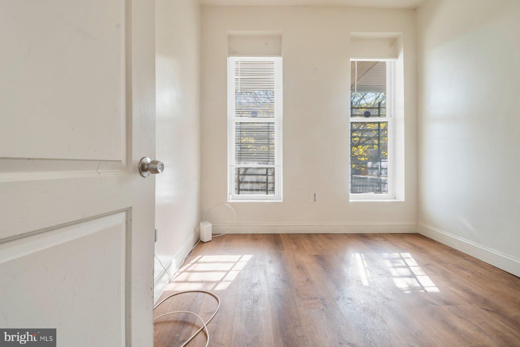 322 South Pulaski Street Baltimore, MD 21223 - Photo 4 of 28 an empty room with wooden floor and windows