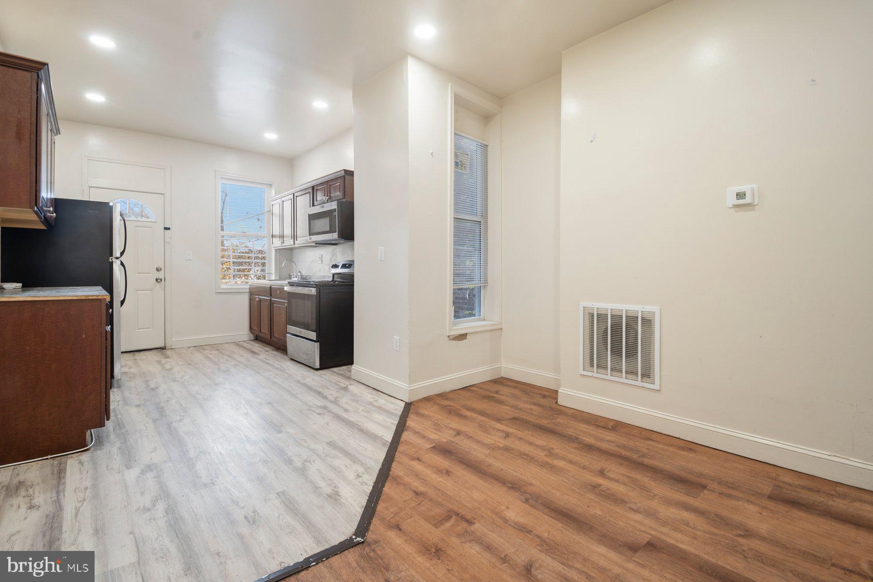 322 South Pulaski Street Baltimore, MD 21223 - Photo 8 of 28 a large white kitchen with cabinets and wooden floor
