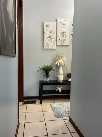 a bath room with a table and paintings on the wall