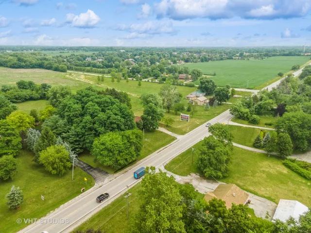an aerial view of a house with a yard and lake view