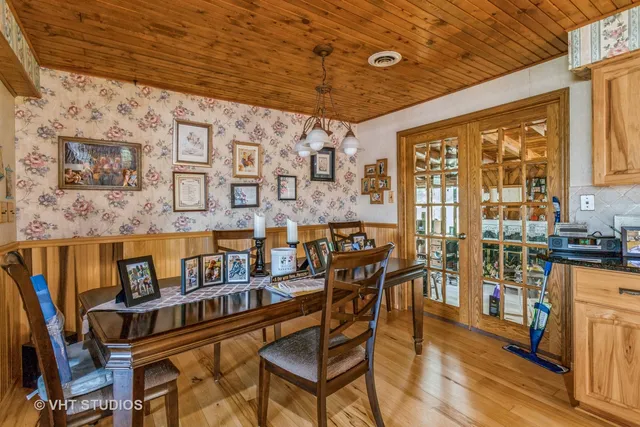 a dining room with furniture and a floor to ceiling window