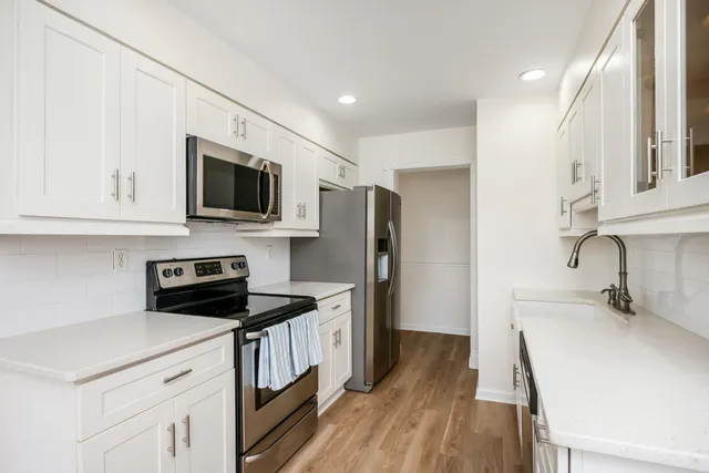 a kitchen that has a microwave a stove and a sink