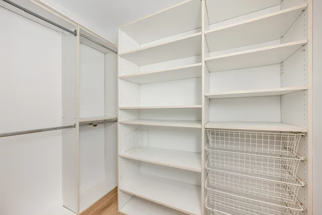 a view of walk in closet with empty racks