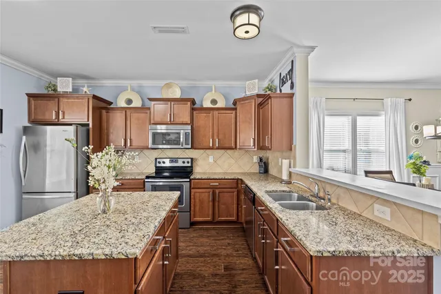 a kitchen with stainless steel appliances granite countertop a sink stove and refrigerator