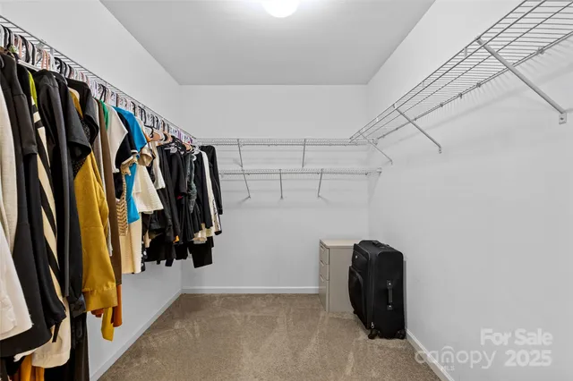a view of walk in closet with clothes and shoes