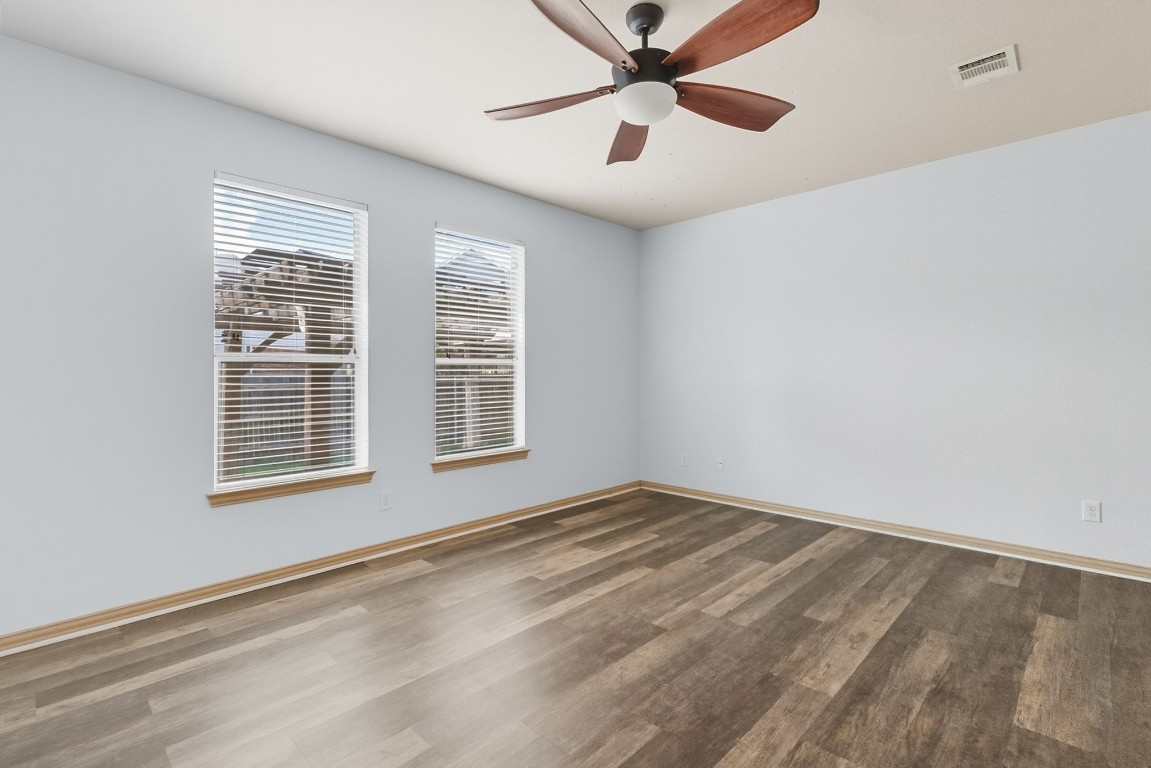 2409 Pauma Valley Way Pflugerville, TX 78660 - Photo 17 of 37 Unfurnished room with dark wood-style floors and a ceiling fan