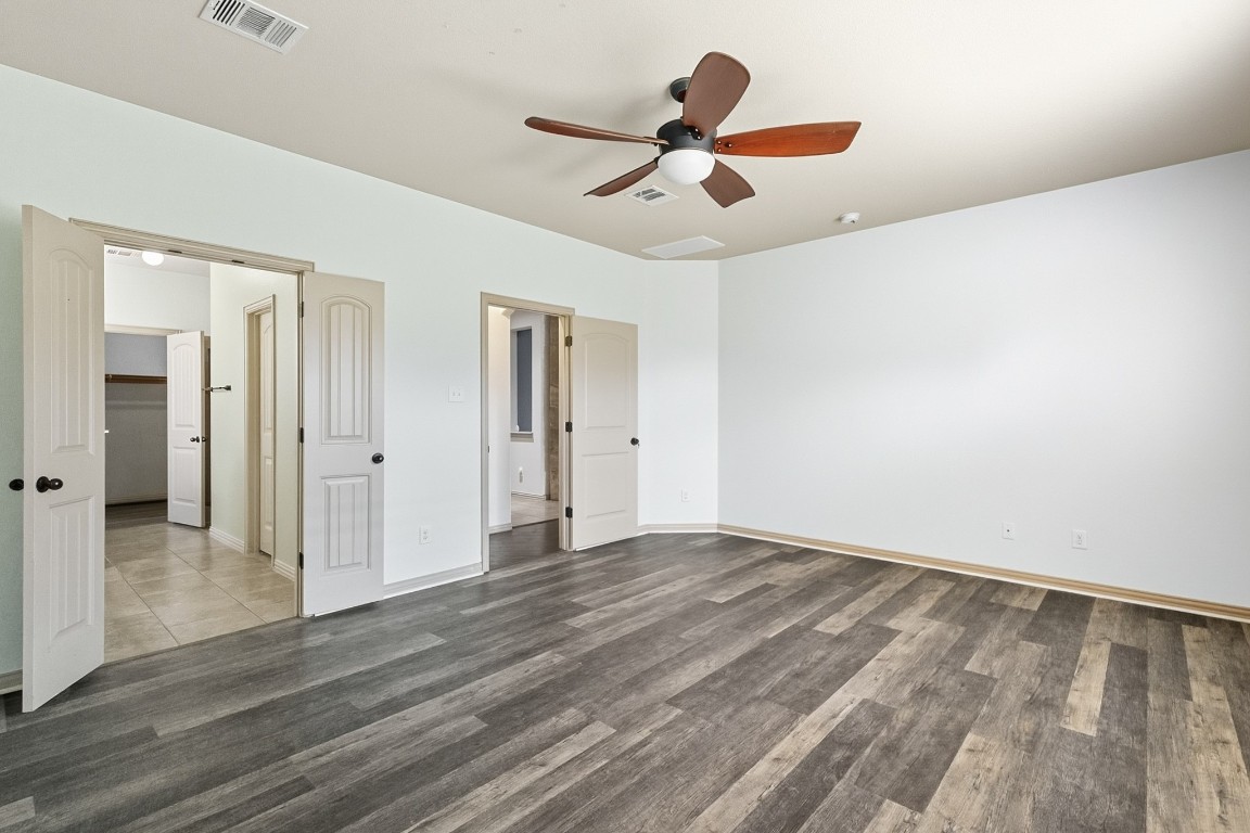 2409 Pauma Valley Way Pflugerville, TX 78660 - Photo 18 of 37 Unfurnished bedroom featuring a ceiling fan and wood finished floors
