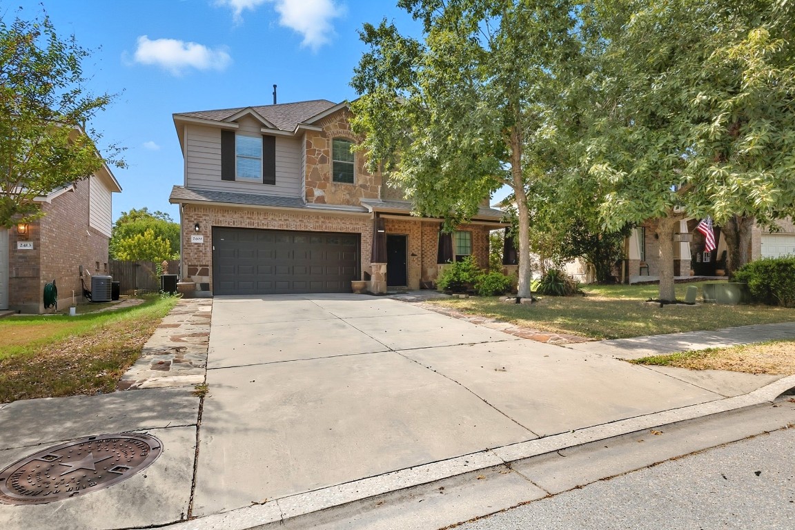 2409 Pauma Valley Way Pflugerville, TX 78660 - Photo 2 of 37 Traditional-style home featuring brick siding, driveway, roof with shingles, a garage, and a front yard