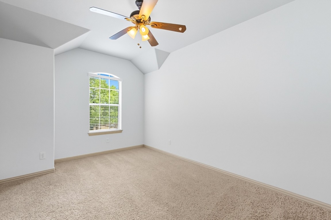 2409 Pauma Valley Way Pflugerville, TX 78660 - Photo 26 of 37 Unfurnished room featuring light colored carpet, a ceiling fan, and vaulted ceiling