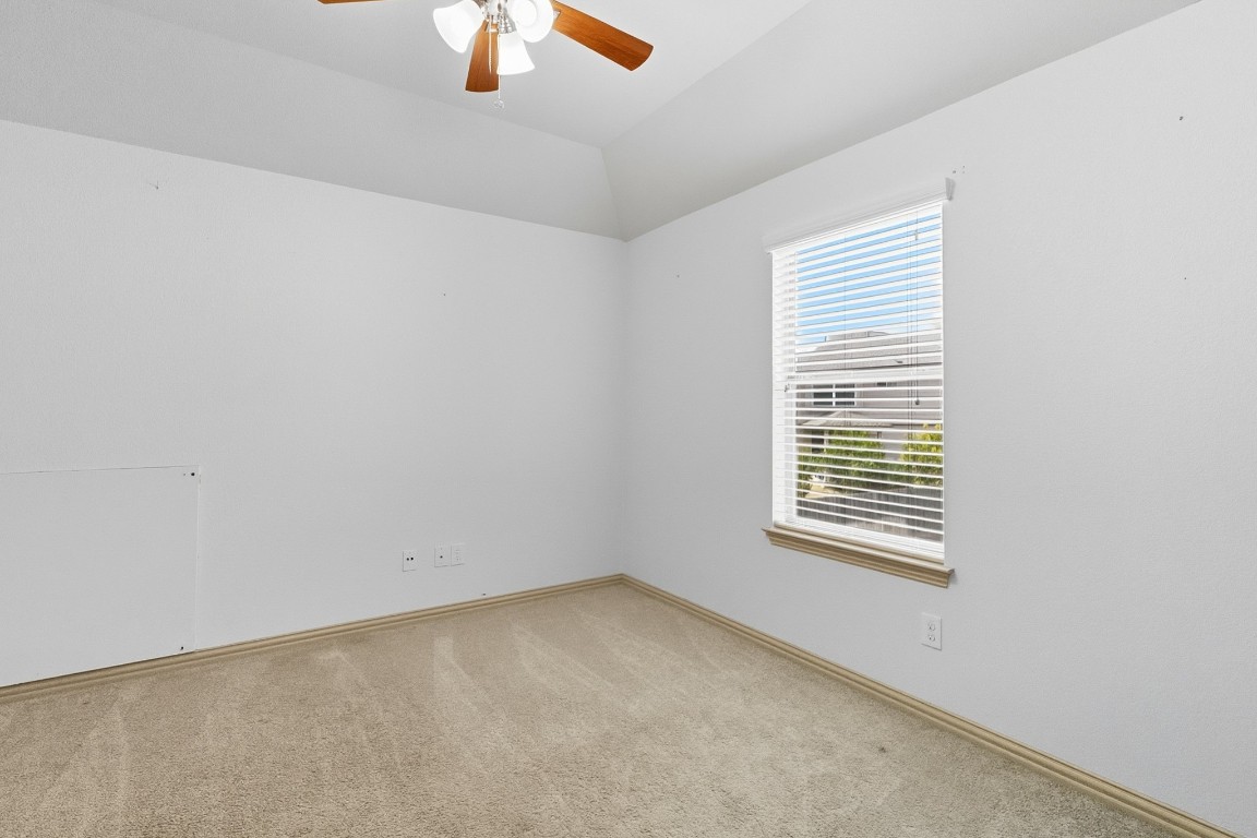 2409 Pauma Valley Way Pflugerville, TX 78660 - Photo 28 of 37 Spare room with light colored carpet, ceiling fan, and lofted ceiling